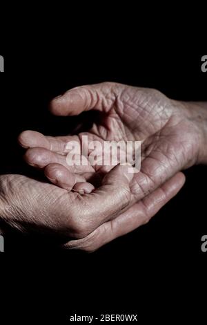 closeup of a young caucasian man holding the hand of a senior caucasian woman Stock Photo