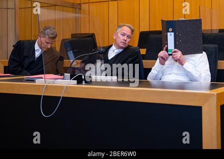 15 April 2020, North Rhine-Westphalia, Münster: The 55-year-old defendant (r) sits next to his lawyers Detlev Binder (l-r) and Carsten Ernst in front of the regional court before the start of the trial. He is said to have drowned his 79-year-old mother from Habier in a well in Neuenkirchen. Photo: Guido Kirchner/dpa Stock Photo