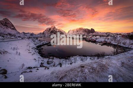 Village Hamnoy Reine with snow and mountains in the Arctic, Lofoten Islands in Norway at sunset, Scandinavia Stock Photo