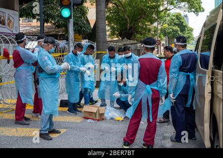 Kuala Lumpur, Malaysia. 15th Apr, 2020. Medical staff prepare to enter a building under the enhanced movement control order (EMCO) in Kuala Lumpur, Malaysia, April 15, 2020. The number of COVID-19 cases in Malaysia totaled at 5,072 after 85 new cases were recorded, the Health Ministry said on Wednesday. The newly confirmed cases of 85 is the first time the number dropped to a double-digit for over a month. Credit: Zhu Wei/Xinhua/Alamy Live News Stock Photo