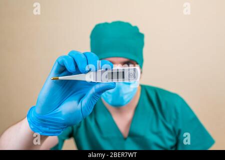 Thermometer in doctors hand on yellow background. Copy space temperature field. selective focus Stock Photo