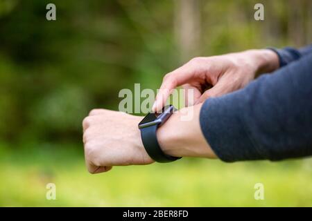 Man in nature using smartwatch app. Close-up hands Stock Photo