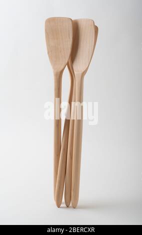 Several long, handmade spatulas of Canadian maple wood set against a white background. Stock Photo