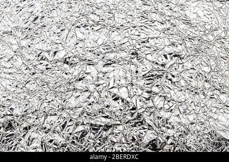 Texture of crumpled aluminum kitchen foil. Silver abstract background for design with copy space for a text. Stock Photo