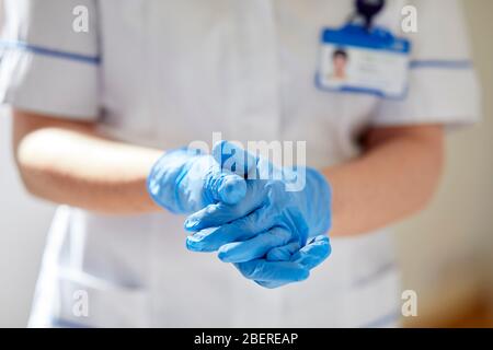 Nurse putting on vinyl gloves Stock Photo
