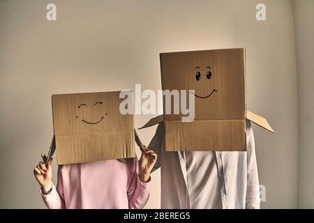 Couple standing in boxes on heads after moving into new house. Stock Photo