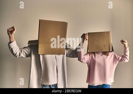 Couple standing in boxes on heads after moving into new house. Stock Photo