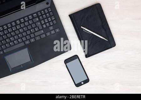 Home workspace with blank smartphone screen and laptop computer Stock Photo