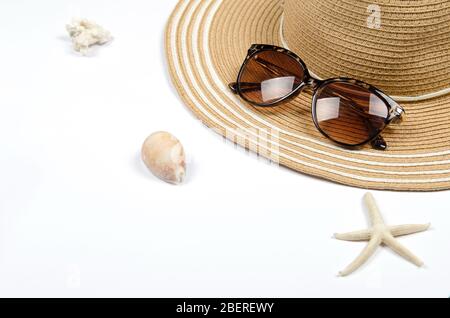 Summer straw hat, sunglasses, shells, starfish on white background. top view, copy space. Stock Photo