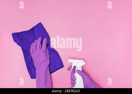 Hand in a rubber yellow glove holds pink bottle of liquid bleach on a white background. cleaning Stock Photo
