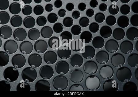 Perforated black matte surface macro close up view Stock Photo