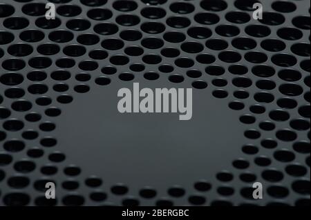 Pattern of vent holes in black plastic surface clsoe up view Stock Photo