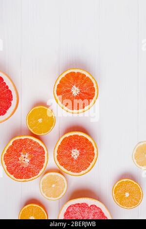 Halves of fresh orange and grapefruit citrus fruits on white wooden background Stock Photo
