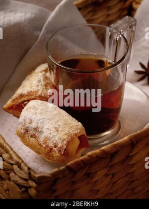 Tea with sweet cookies in a wicker basket on white wooden background Stock Photo