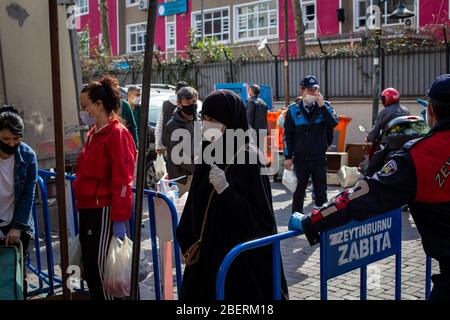 April 14, 2020: Zeytinburnu municipal officers give medical mask to prevent people from coronavirus at street market on April 14, 2020, in Zeytinburnu district, Istanbul, Turkey. On March 27, 2020, the Ministry of the Interior issued an additional circular on market places as part of struggle the coronavirus outbreak. Accordingly, the sale of non-essential supplies other than basic food and cleaning agents will not be allowed. Necessary measures will be taken by the municipalities regarding hygiene and disinfection in the market places. (Credit Image: © Tolga Ildun/ZUMA Wire) Stock Photo