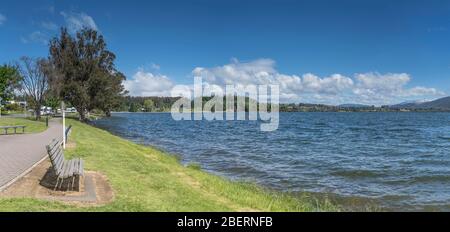 TE ANAU, NEW ZEALAND - November 20 2019: cityscape with bench on lake shore at touristic village, shot in bright light on november 20 2019 at Te Anau, Stock Photo