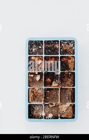 Ice cube tray with frozen coffee on grey table, closeup. Space for text  Stock Photo - Alamy