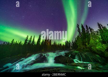 Aurora over the Ramparts waterfall on the Cameron River in Canada. Stock Photo