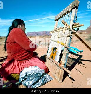 Monument Valley, U.S.A.-September 19,2001: Navajo Indian Woman Weaving Rug at Monument Valley, Utah, U.S.A. Stock Photo