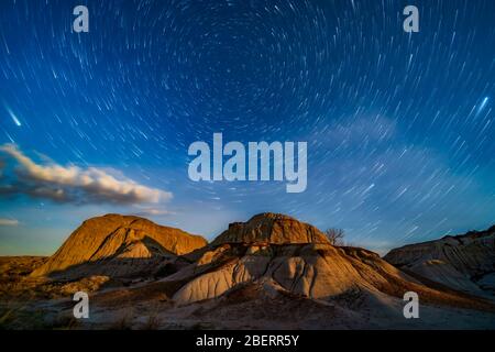 Moonrise over the eroding formations of Dinosaur Provincial Park, Alberta, Canada. Stock Photo