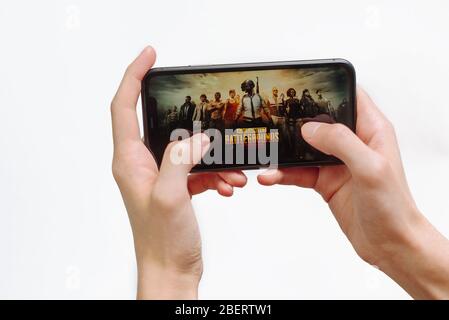 Samara Russia - 04.05.2020: Hands holding a smartphone Iphone 11 with PUBG mobile game on display screen, Illustrative Editorial. Mobile game loading Stock Photo