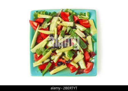 Sliced slices of vegetables on a square porcelain dish isolated on white Stock Photo