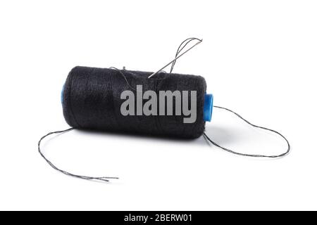 Spool with black threads and a sewing needle stuck into it, isolated on a white background Stock Photo