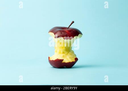 Apple core on a blue background. Food, fruit and vegetarian concept. Stock Photo