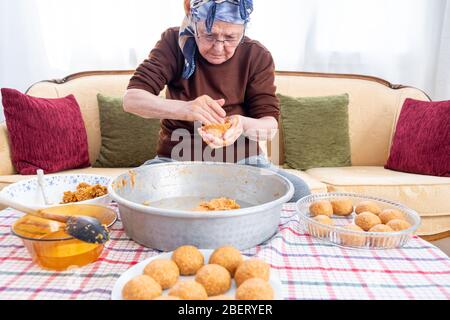 Traditional Turkish Food; Stuffed Meatballs,  Turkish known as 'icli kofte'. Woman making Stuffed Meatballs at home. Stock Photo