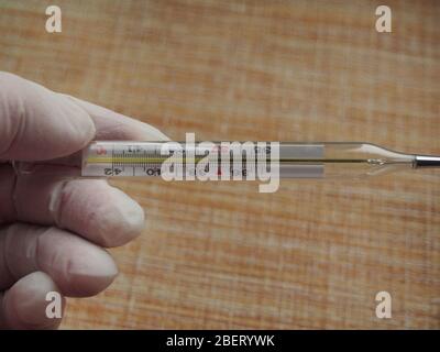 analog mercury thermometer with 37,7 °C of temperature, fever, flu, corona  virus, covid19, on green background Stock Photo - Alamy