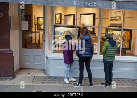 Three children looking at art through Thackeray art shop window Stock Photo