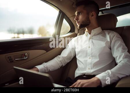 Man in back seat of moving car Stock Photo