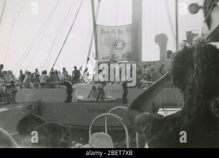 Vintage photograph, “King Neptune ceremony on the SS Argentina, Saturday, June 25, 1955” in the Atlantic Ocean. The banner reads, “Behold the King and His Conch.” The line-crossing ceremony is an initiation rite that commemorates a person's first crossing of the Equator. SS Argentina was a US turbo-electric ocean liner. SOURCE: ORIGINAL PHOTOGRAPH Stock Photo