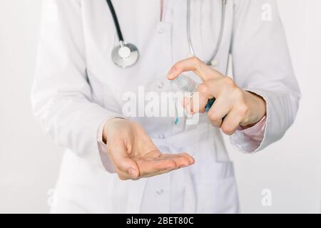 Cropped image of female doctor hands using wash hand sanitizer gel dispenser, against coronavirus or Covid-19. Antiseptic, Hygiene and Healthcare Stock Photo