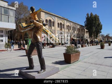 Sculpture of man carrying a carpet, in Zand walking street in Vakil Bazaar area in Shiraz, Fars Province, Iran, Persia, Middle East Stock Photo