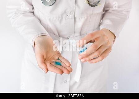 Cropped close up photo of female doctor hands using sanitizer antiseptic gel, disinfecting hands. COVID-19 corona virus disease epidemic, global Stock Photo
