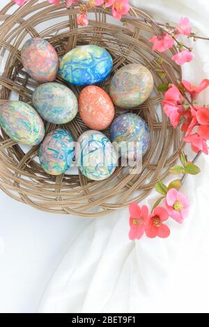 Coconut sticks plate with colorful Easter eggs on white background Stock Photo
