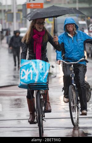 Amsterdam, Netherlands - June 2016: Biking in the rain Stock Photo