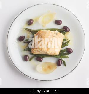 Meal of Boiled Cod Fish with black olives and green beans Stock Photo