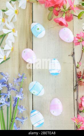 Α brunch of Japanese Quince, hyacinthus,Poet's Narcissus flowers and Easter eggs on wooden table Stock Photo