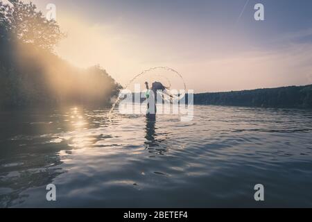 cute girl with long blond hair posing as model in water in golden hour time Stock Photo