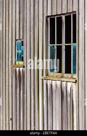 Abstract image of weathered wood and a broken window on an old net loft on the Steveston waterfront Stock Photo