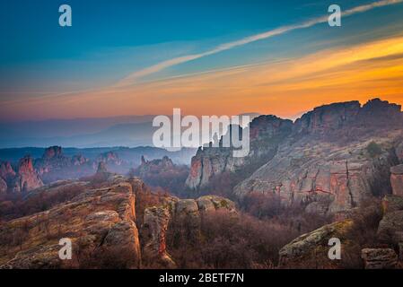 Beautiful sunset painting the sky over the oddly shaped sandstone rocks in the epic town of  Belogradchik, northwest Bulgaria Stock Photo
