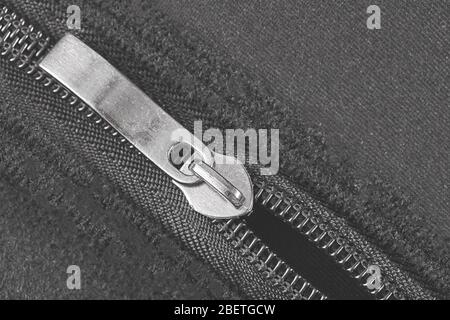 Black zipper and lock on textile background. Close up. Top view. Stock Photo