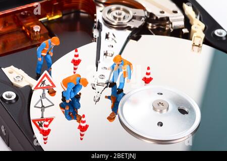 Conceptual image of miniature figure people looking for problems on a computer hard drive Stock Photo