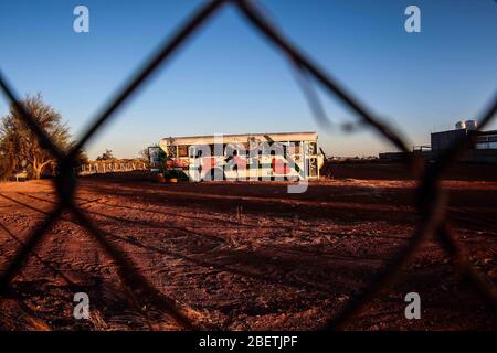 Abandoned passenger truck in La Manga neighborhood. seen through steel mesh fence.   Camion de pasajeros abandonado en la colonia la Manga. visto trav Stock Photo