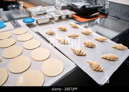 Small Business. Bakery shop production puff pastry and croissants isolated on tray close-up Stock Photo