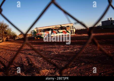 Abandoned passenger truck in La Manga neighborhood. seen through steel mesh fence.   Camion de pasajeros abandonado en la colonia la Manga. visto trav Stock Photo