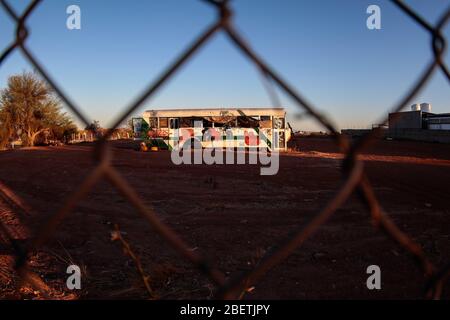 Abandoned passenger truck in La Manga neighborhood. seen through steel mesh fence.   Camion de pasajeros abandonado en la colonia la Manga. visto trav Stock Photo