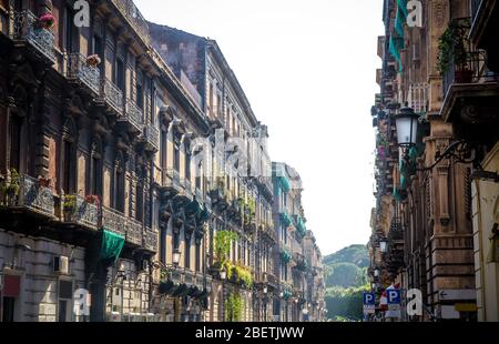 View of typical classic Sicilian street and buildings with balconies, windows with shutters, lamps in old style in Catania city, Sicily island, Southe Stock Photo